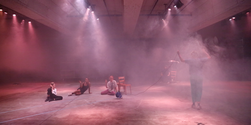 Performance Gruppe in pinkem Licht 